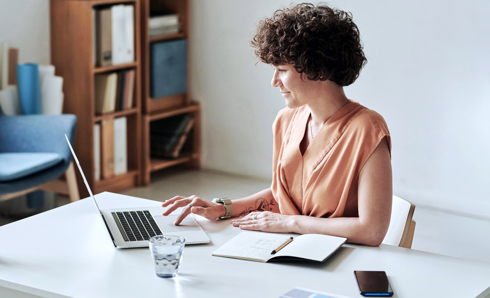 Frau sitzt am Schreibtisch am Laptop